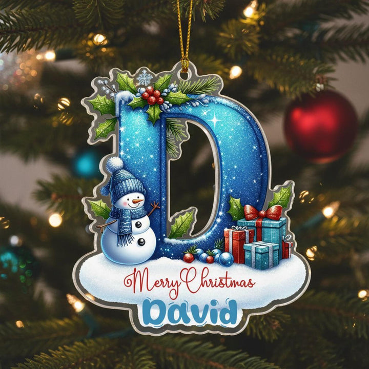 A Christmas ornament with a snowman, presents, and a red ornament on a tree.