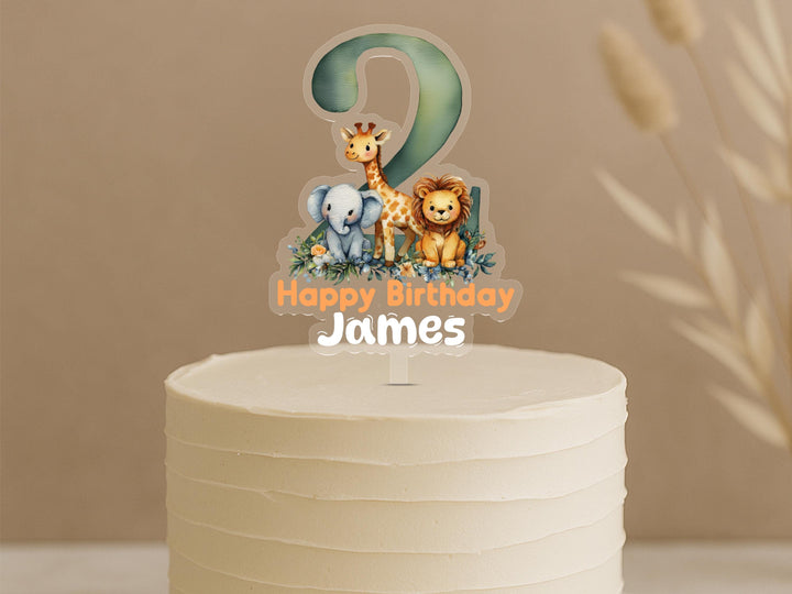Personalised safari cake topper showing number 2 with elephant, giraffe and lion animals plus custom name James on white birthday cake