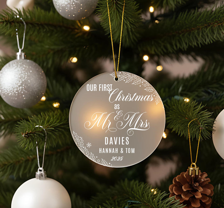 A Christmas tree decorated with ornaments, including a large ornament that reads &quot;Our first Christmas as Mr & Mrs Davies Hannah & Tom 2025&quot;.