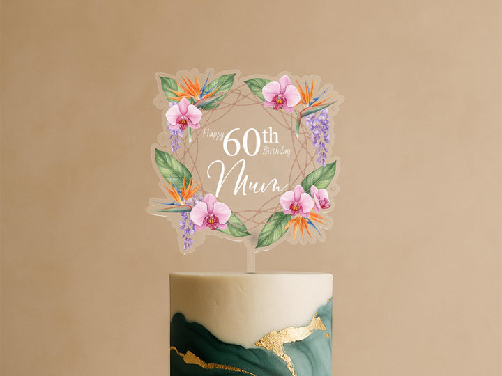A birthday cake with a floral wreath topper that says &quot;Happy 60th Birthday Mum&quot;.