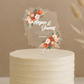 Personalised boho wedding cake topper featuring geometric frame with coral roses, pampas grass and custom names Megan & James married 23.10.2025 on white wedding cake