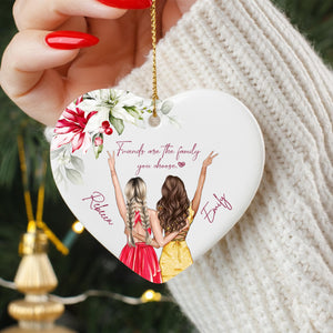 A heart-shaped ornament with two women in a loving embrace, surrounded by flowers and the text "Friends are the family you choose".