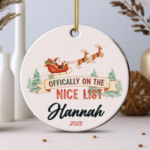 An ornament with a Santa Claus sleigh and reindeer, along with the text " Officially on the NICE LIST Hannah" and the year "2025".