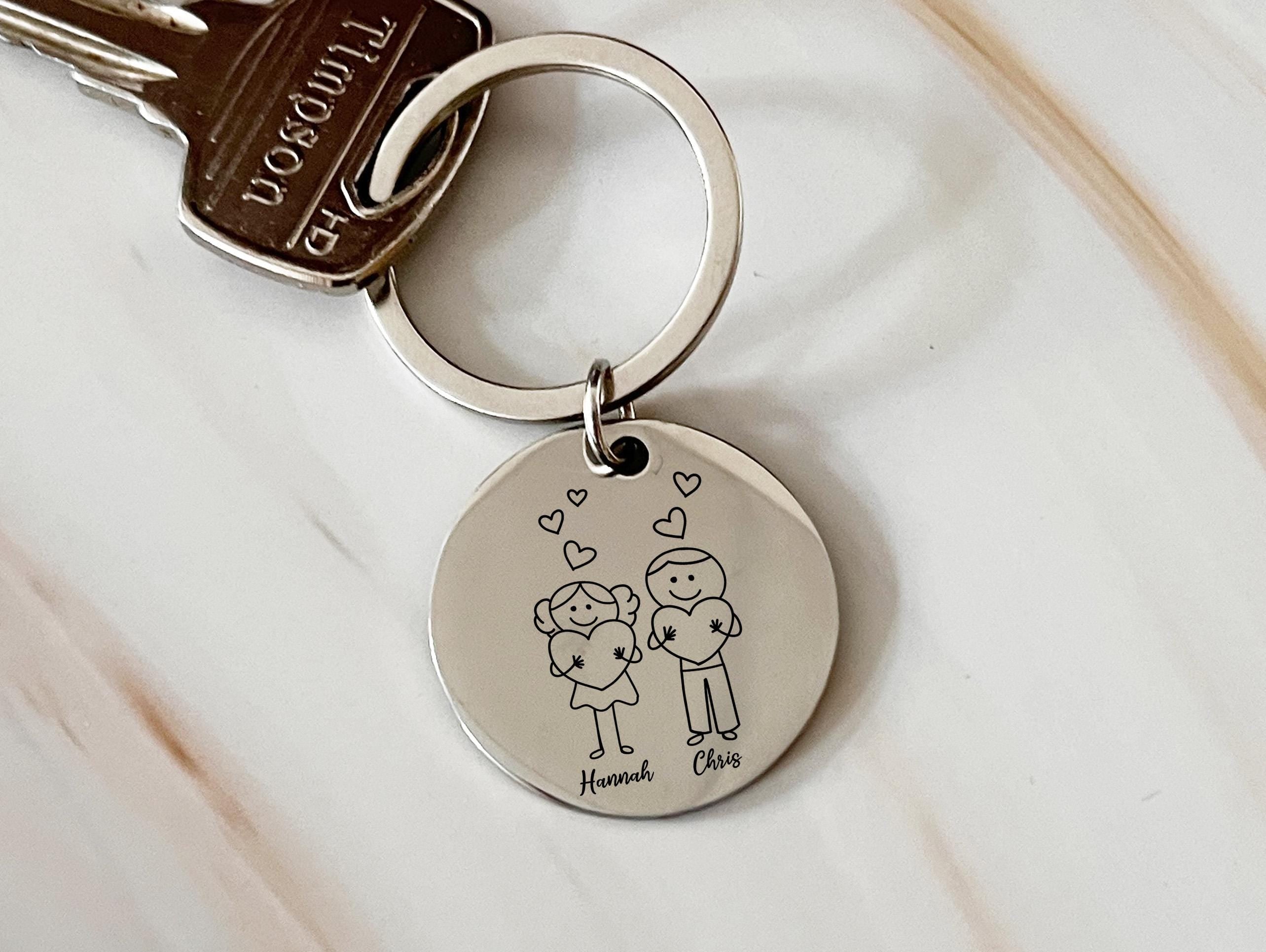 a keychain with a picture of a boy and a girl holding a heart