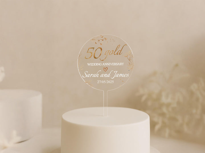 a 50th wedding anniversary cake topper on a white cake