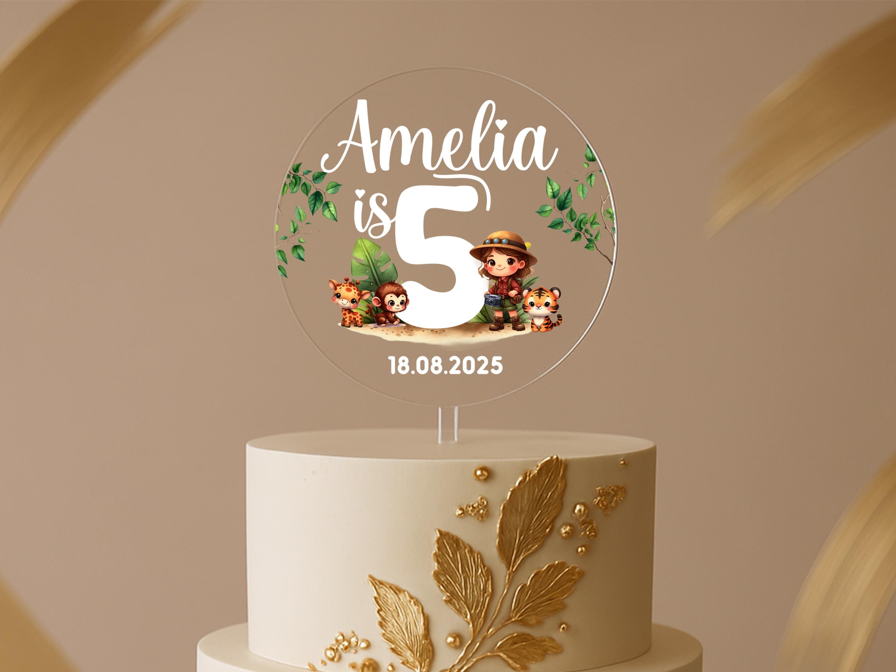 a white cake with a gold leaf decoration on top of it