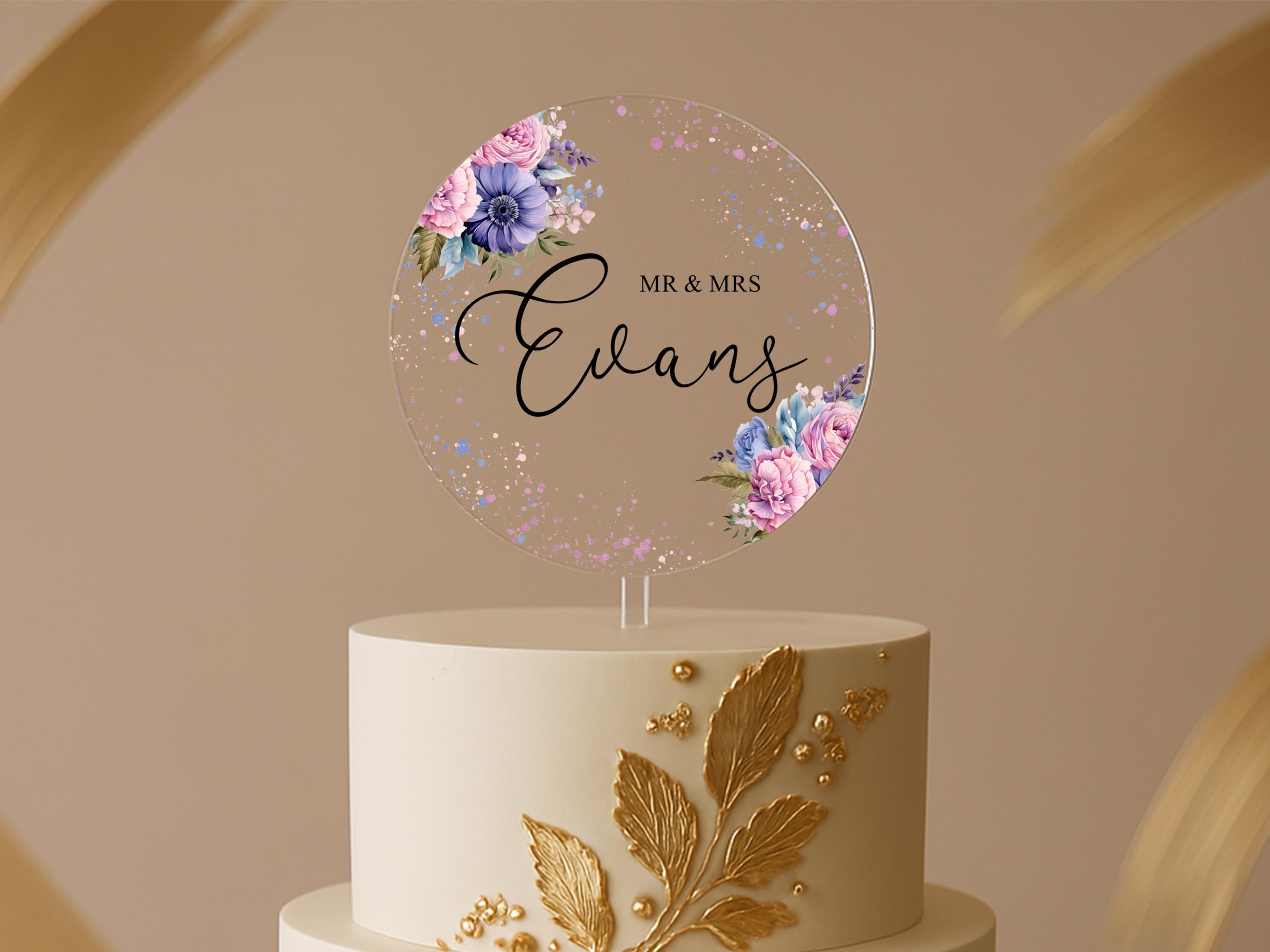 a wedding cake with a name and flowers on it