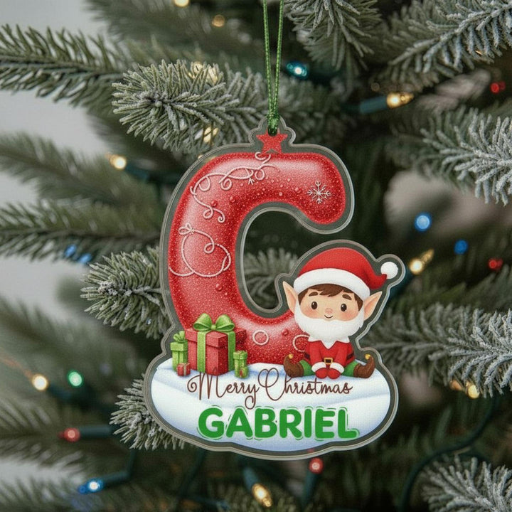 A Christmas ornament with a red glittery letter &#39;C&#39; and a small elf wearing a Santa hat. The ornament has a personalized message that says &quot;Merry Christmas Gabriel&quot;.