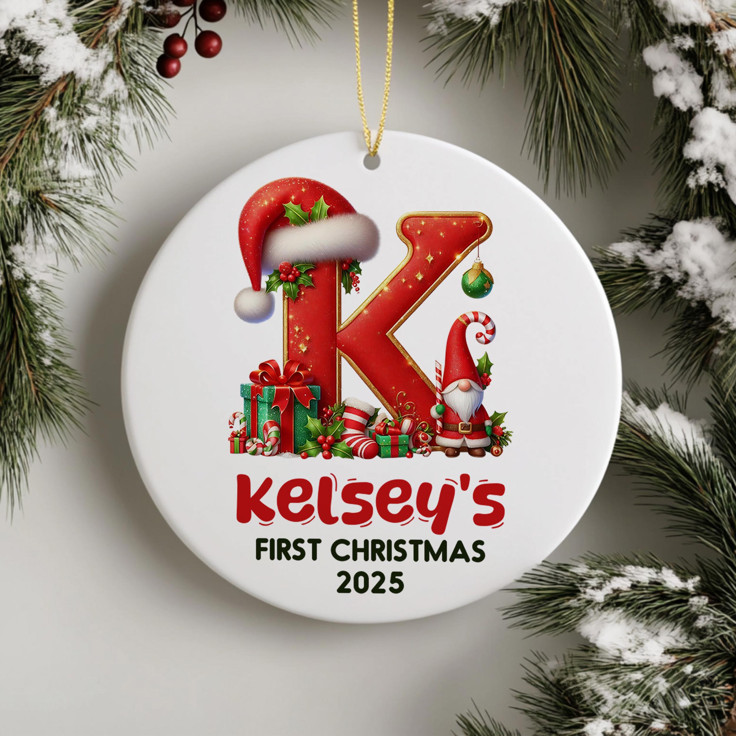 A white Christmas ornament with a red and gold design featuring a letter "K" and a gnome, surrounded by Christmas decorations such as pine branches and berries.