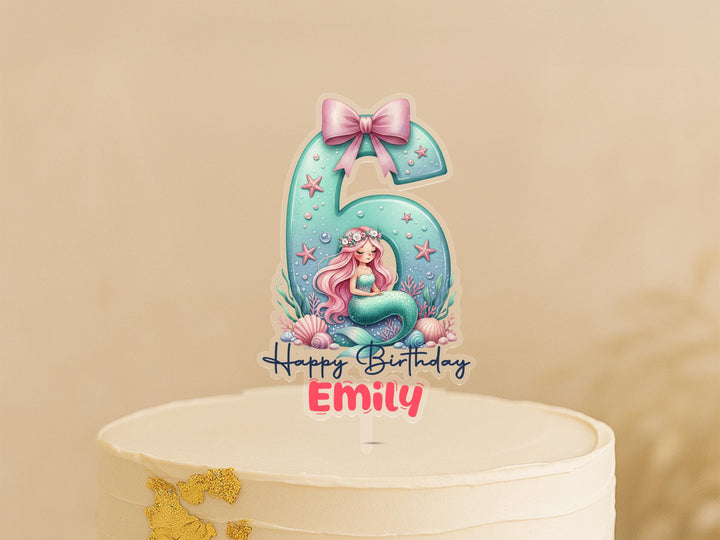 A birthday cake topper featuring a mermaid character and the number 6.
