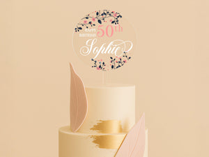 a white cake with pink and gold decorations