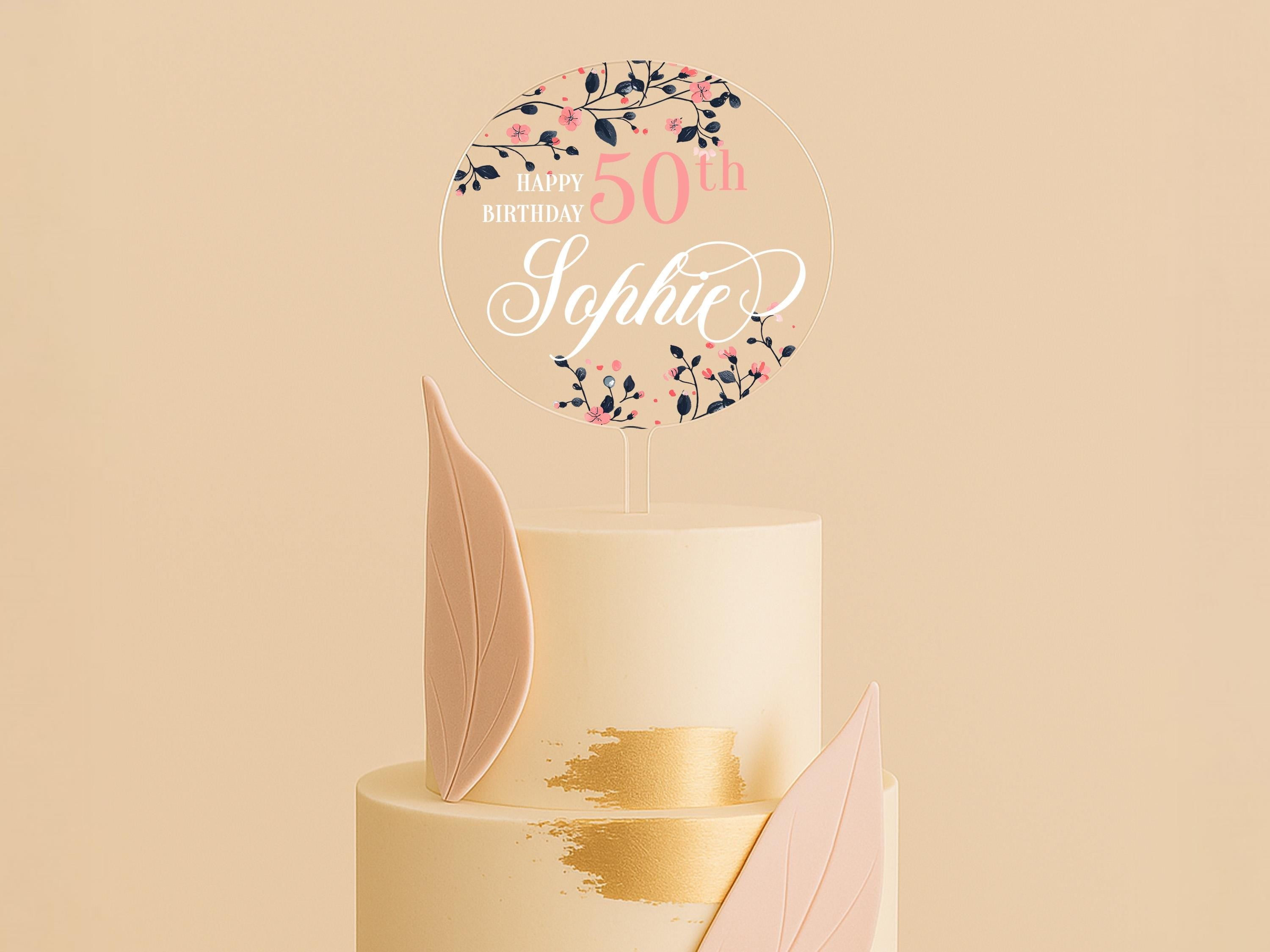 a white cake with pink and gold decorations