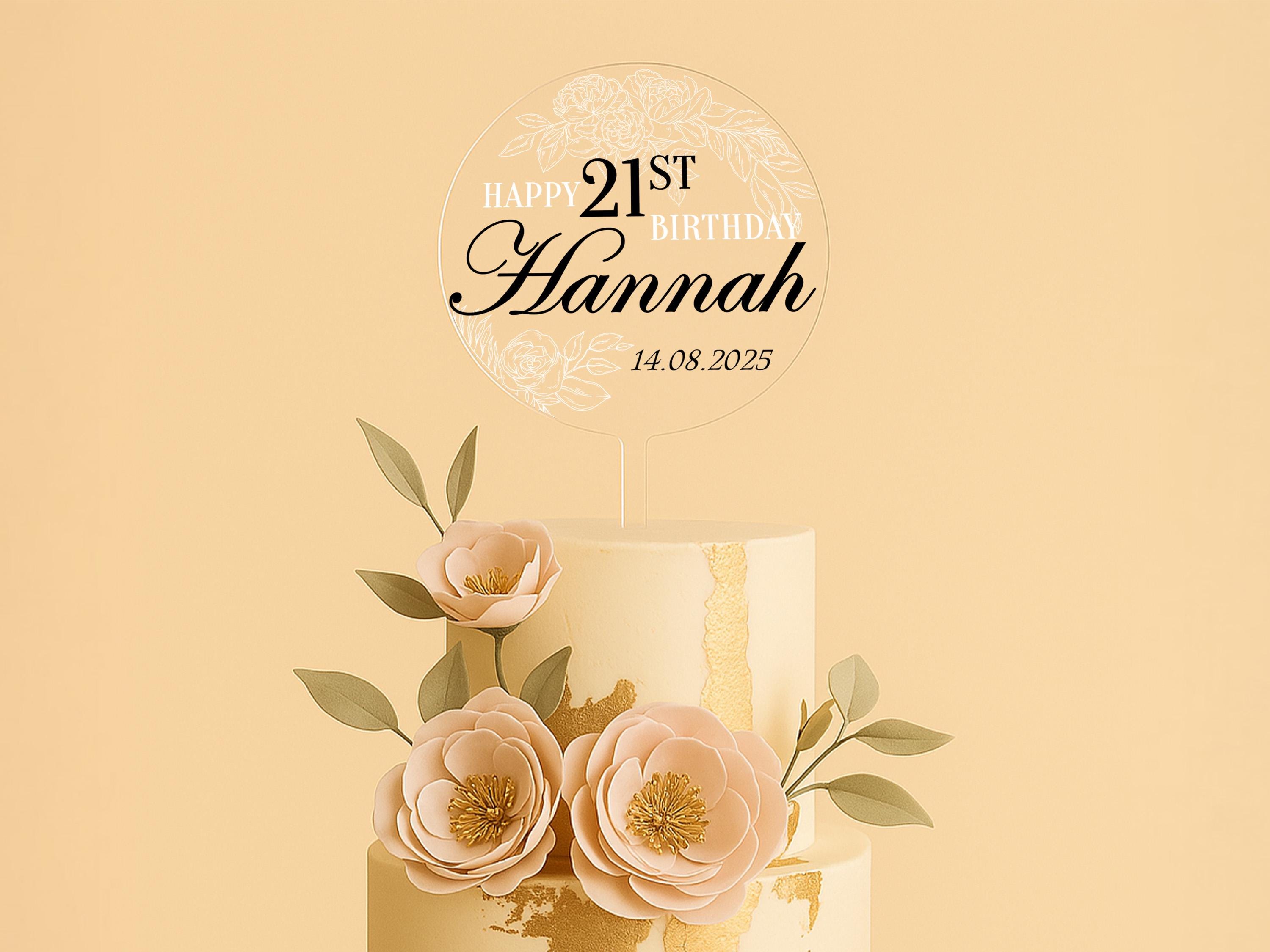 a three tiered cake with flowers and a happy 21st birthday sign