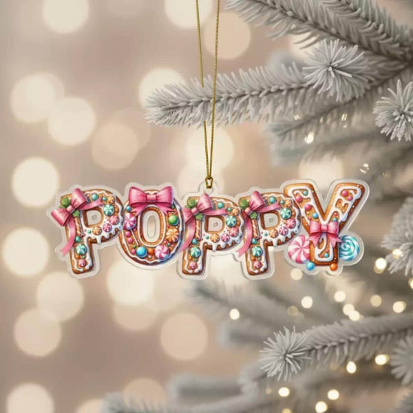 A Personalised gingerbread ornament shaped like the word &quot;POPPY&quot; made of colorful candy and decorations, hanging on a Christmas tree.