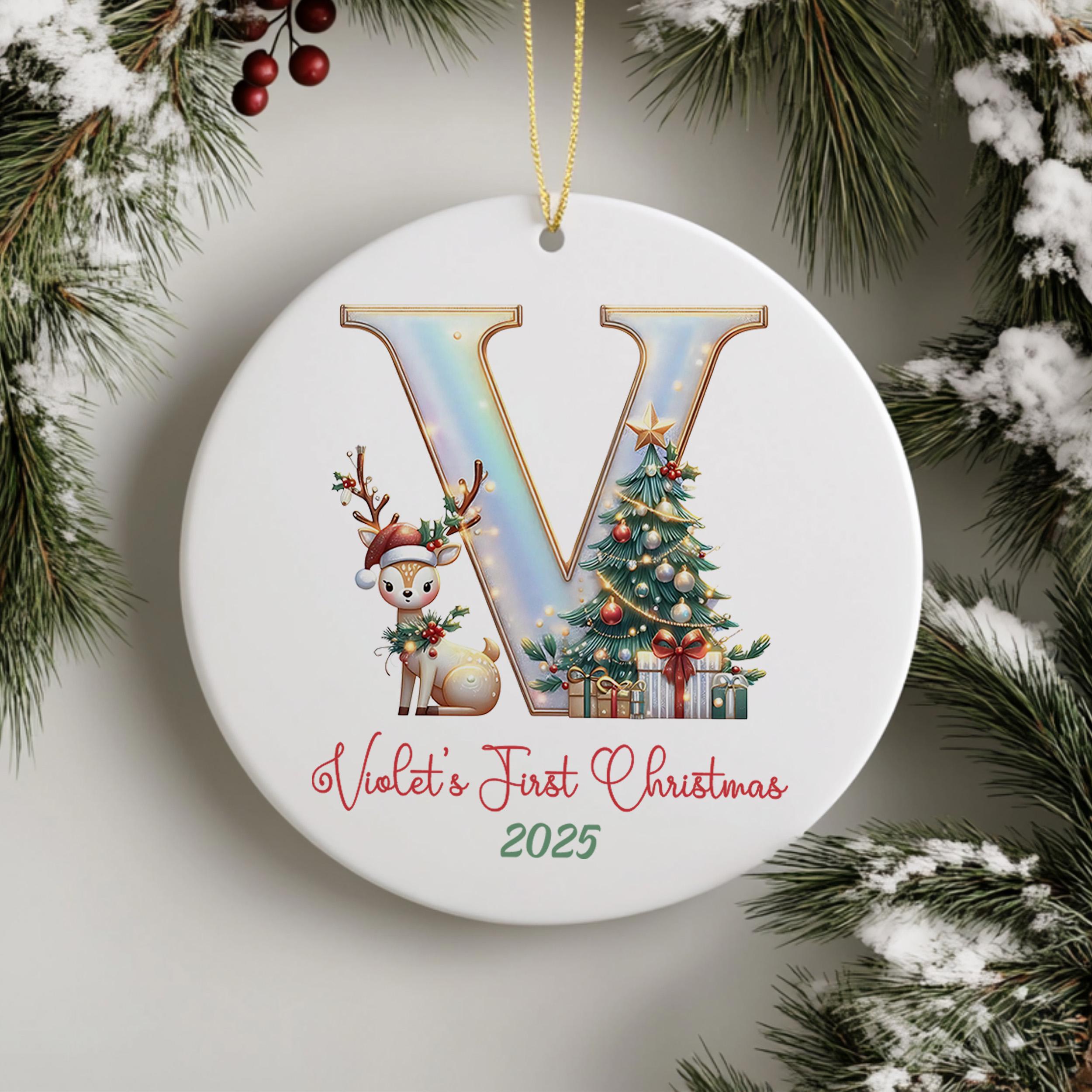 A white ceramic ornament with a large letter "V" and a reindeer, along with a Christmas tree and presents, hangs on a wall.