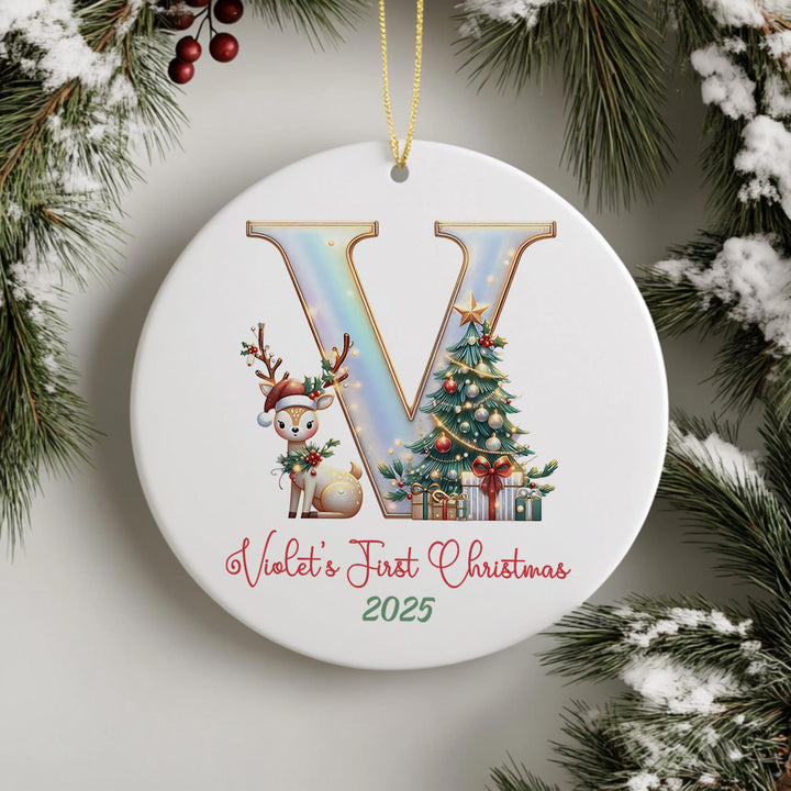 A white ceramic ornament with a large letter &quot;V&quot; and a reindeer, along with a Christmas tree and presents, hangs on a wall.