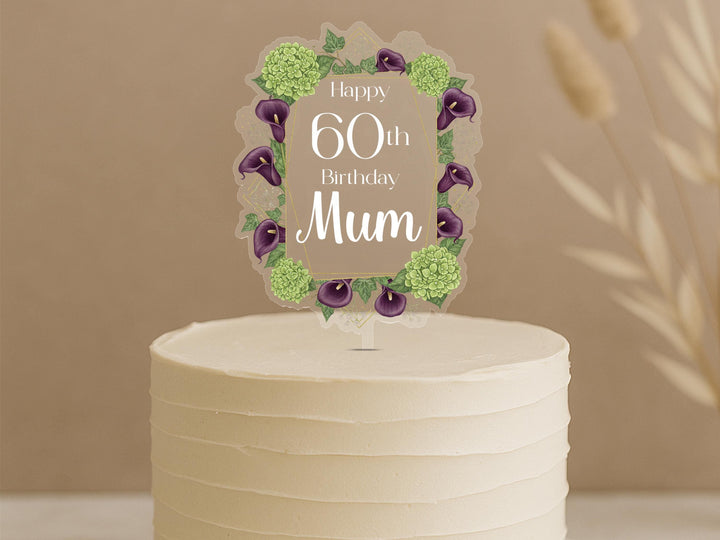 Personalised 60th birthday cake topper featuring elegant oval frame with purple calla lilies, green hydrangeas and custom name Mum on white celebration cake