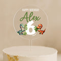 a birthday cake with a dinosaur topper on it