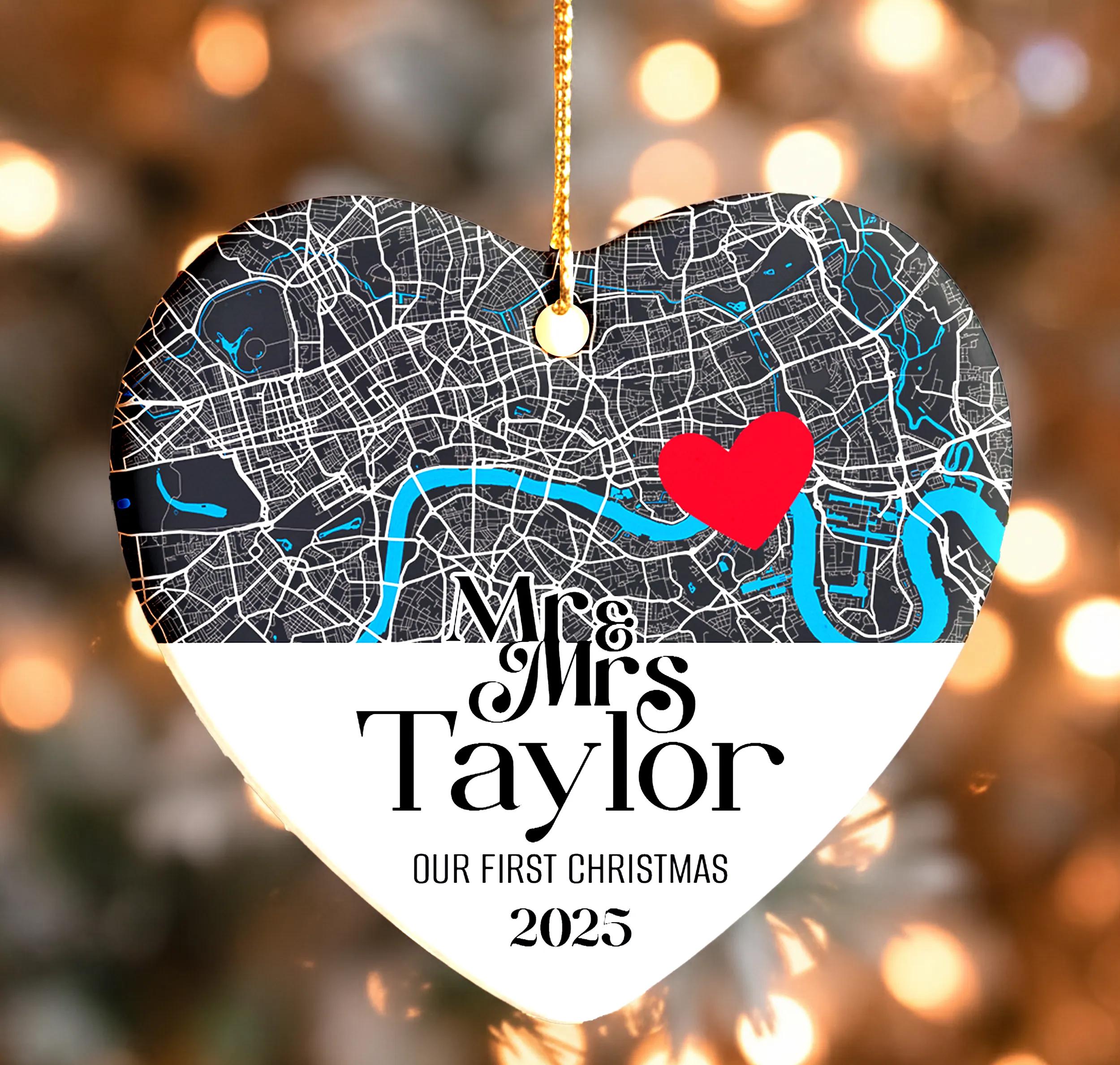 A heart-shaped ornament with a map of London and a red heart symbol, along with the text "Mr & Mrs Taylor" and "OUR FIRST CHRISTMAS 2015".