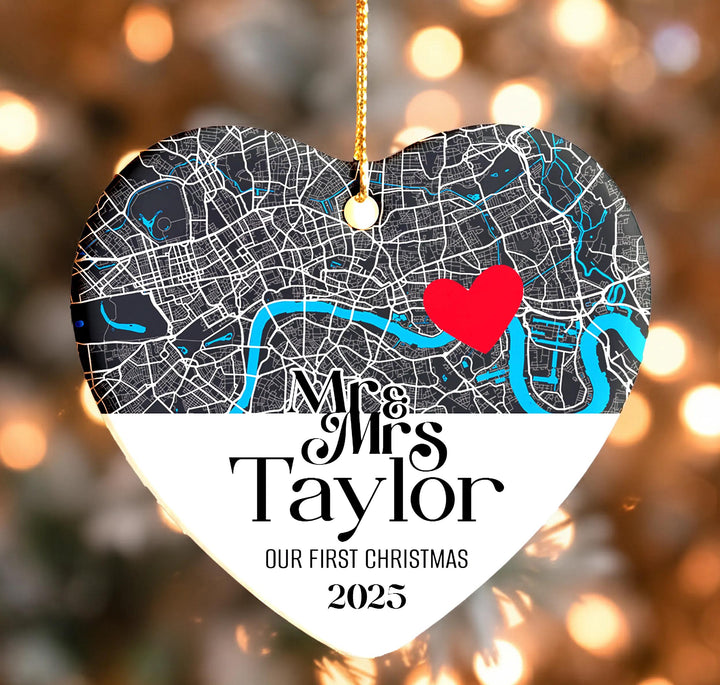 A heart-shaped ornament with a map of London and a red heart symbol, along with the text &quot;Mr & Mrs Taylor&quot; and &quot;OUR FIRST CHRISTMAS 2015&quot;.