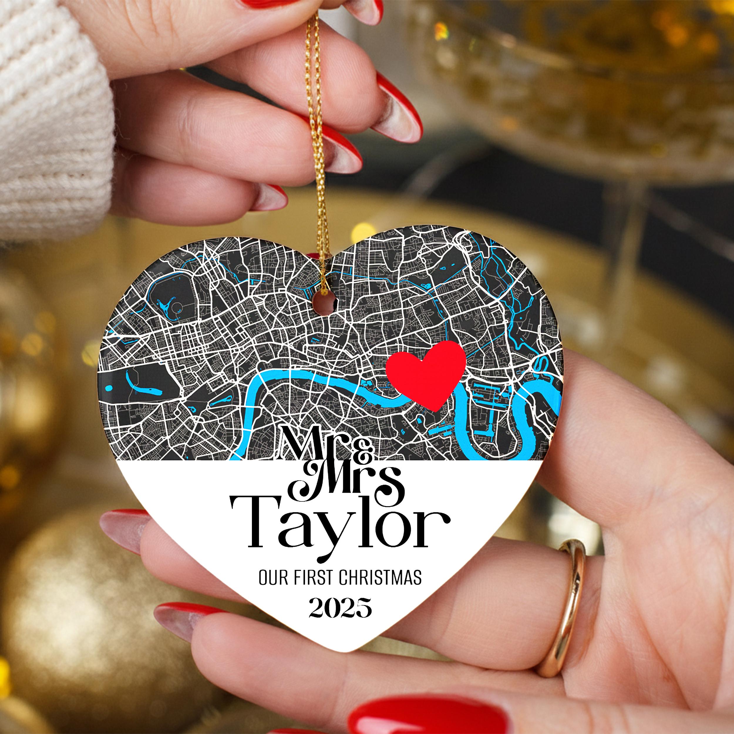 A person's hand holding a heart-shaped ornament with a map of London and a red heart symbol.