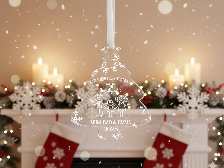 A Christmas ornament hanging in front of a fireplace, with snowflakes falling in the background.