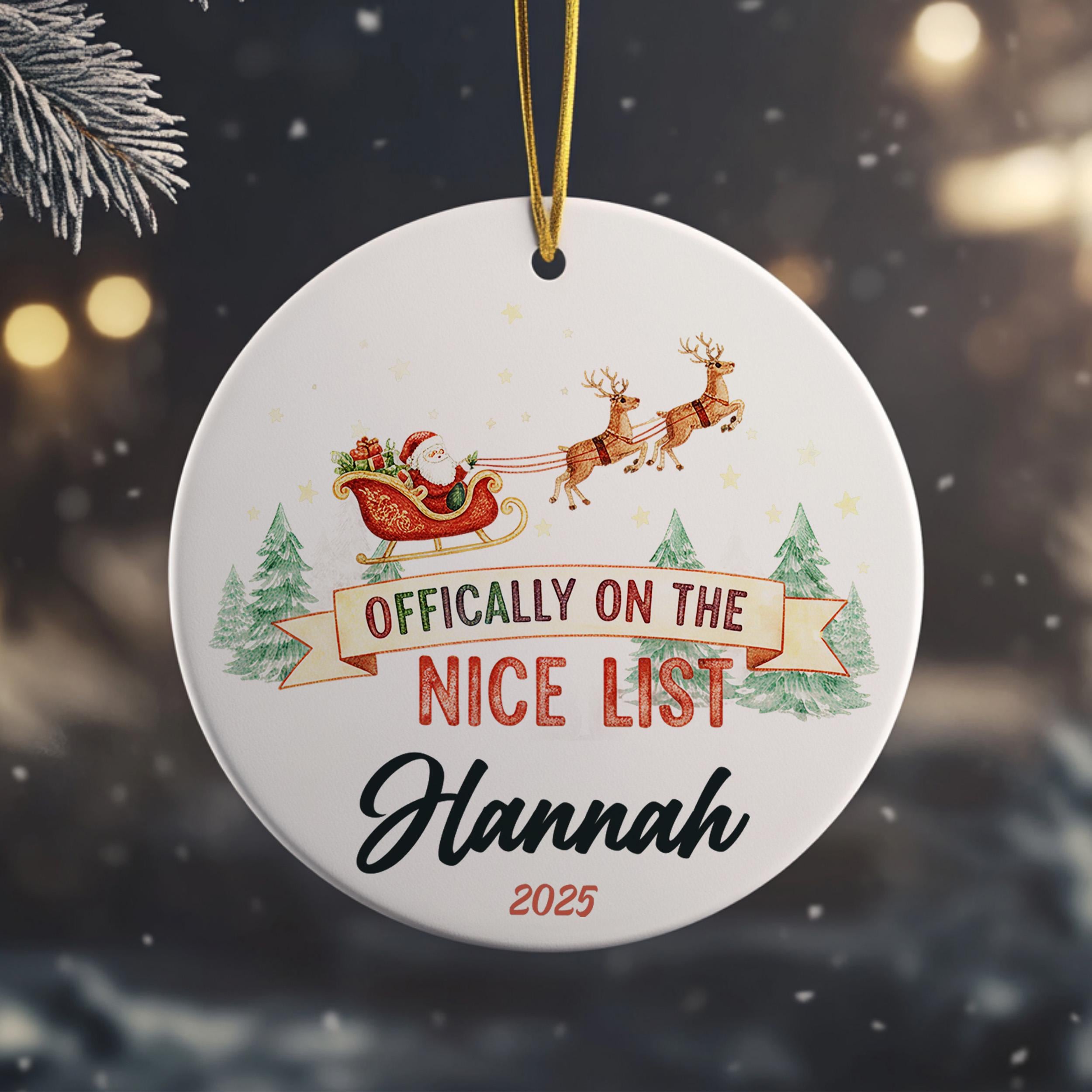 A white ornament with a Santa Claus sleigh and reindeer, along with the text " Officially on the NICE LIST Hannah" and the year "2025".