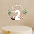 a cake topper with a picture of two raccoons on it