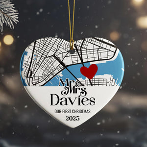 A heart-shaped ornament with a map of a city and a red heart symbol, along with the text "Mr & Mrs Davies" and "OUR FIRST CHRISTMAS 2025".