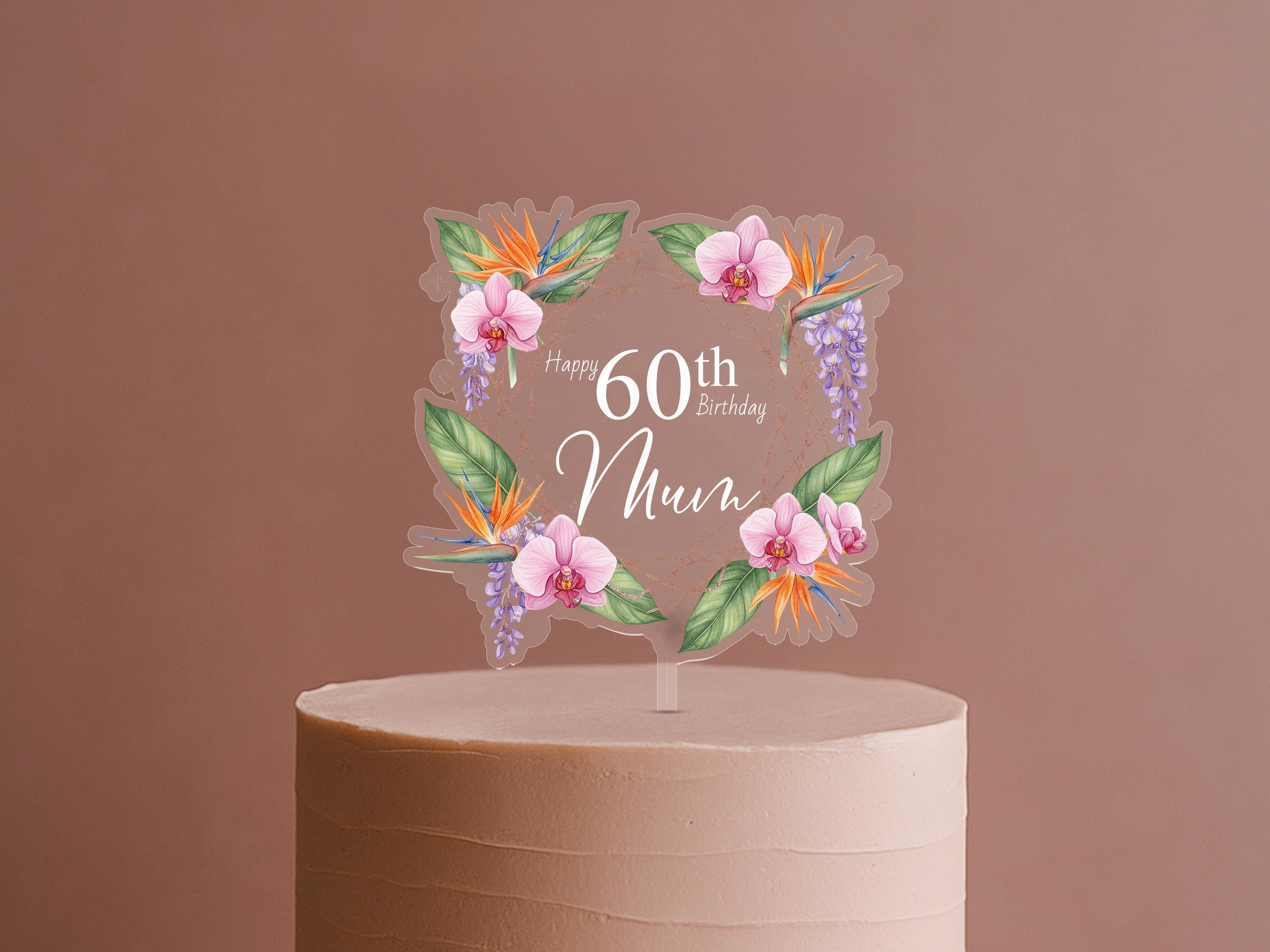 A cake topper with a floral design and the text "Happy 60th Birthday Mum" on it.
