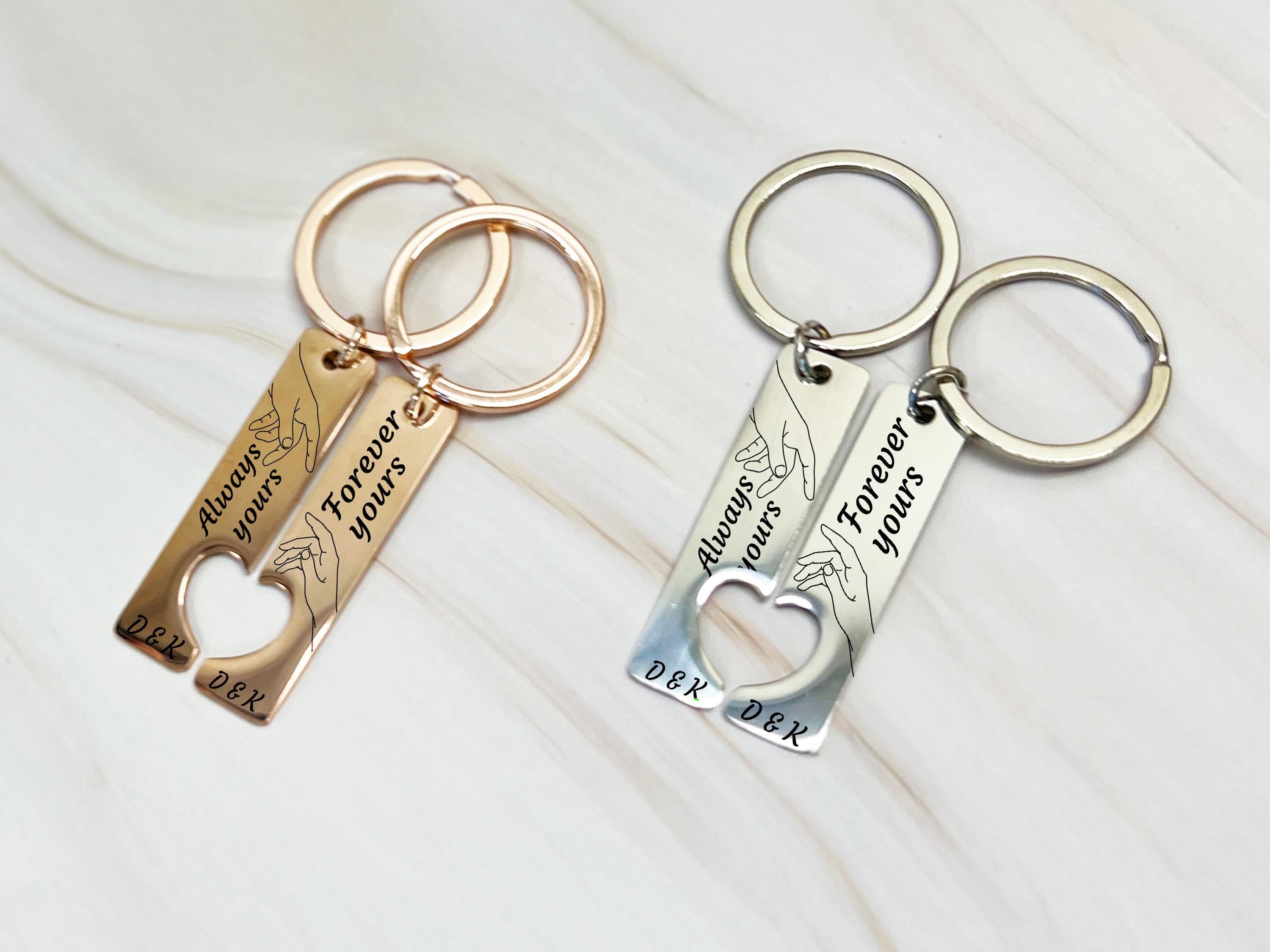 Engraved couple’s keychains, rose gold stainless steel, connecting heart cutout and hand line art, perfect for couples.