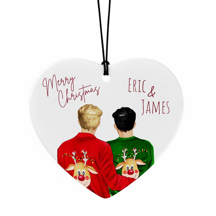 A heart-shaped ornament with two people wearing Christmas sweaters with reindeer designs. The text on the ornament reads &quot;Merry Christmas Eric & James&quot;.