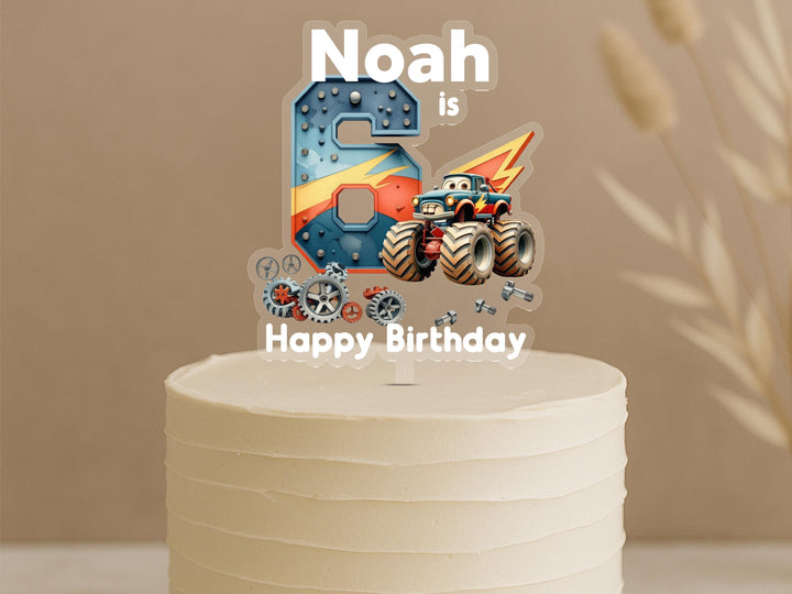 Custom monster truck birthday cake topper featuring number 6 with vehicle details, mechanical gears and personalised name Noah on celebration cake