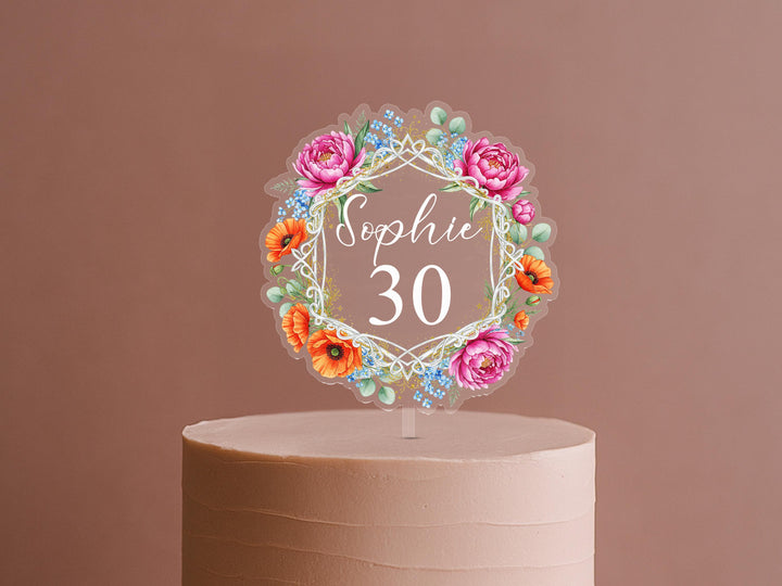 A cake topper with a floral design and the name &quot;Sophie&quot; written on it.
