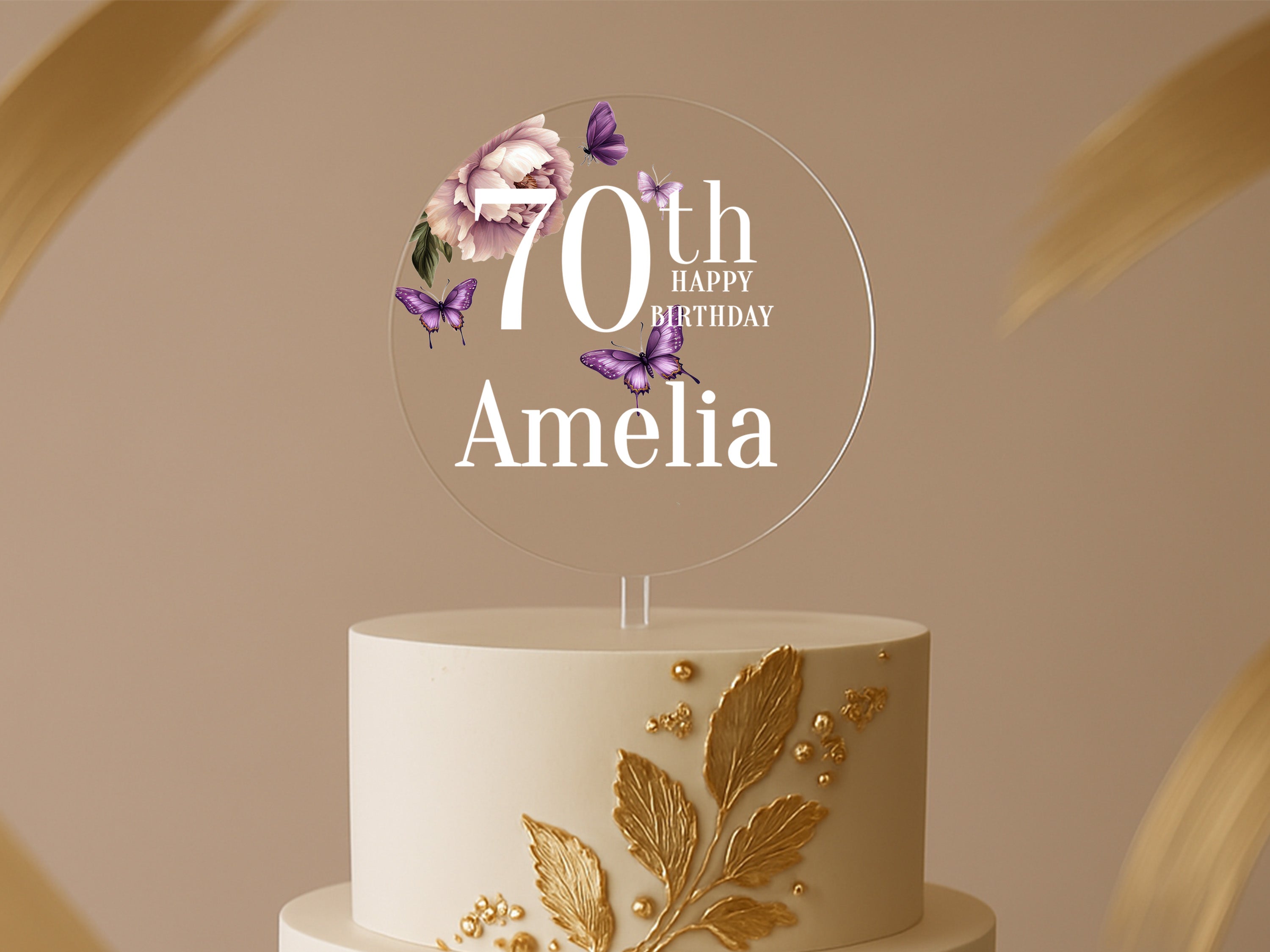 a white and gold cake with a 70th birthday cake topper