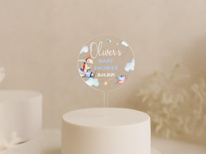 a baby shower cake topper sitting on top of a white cake