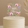 Personalised 60th birthday cake topper featuring elegant tropical floral design with orchids, bird of paradise flowers, purple wisteria and custom name Mum in square frame on white celebration cake