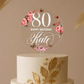 Round 80th birthday cake topper with pink florals, butterflies, and custom name