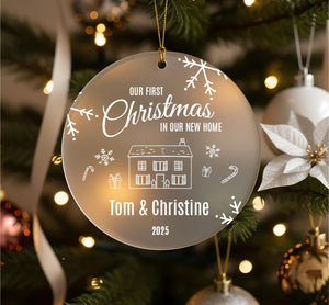 A Christmas ornament hanging on a tree, with the text "Our first Christmas in our new home" and the names "Tom & Christine" below it.