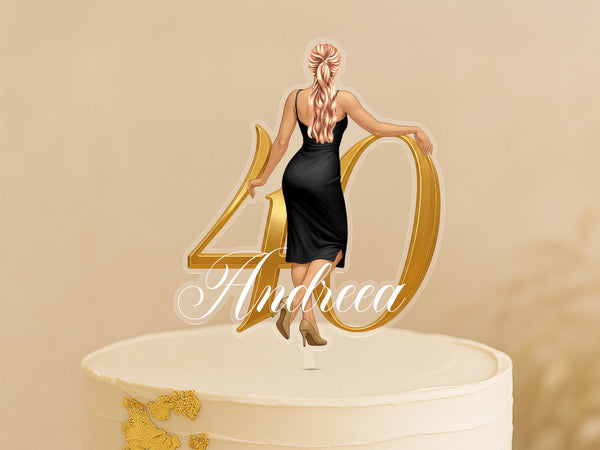 A woman in a black dress is standing on top of a white cake with the number 40 and the name "Andrea" written on it.
