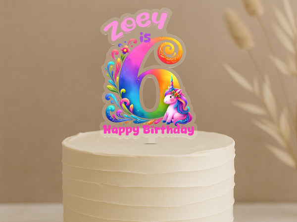 Personalised rainbow swirl unicorn cake topper showing vibrant number 6 with magical swirl patterns, cute unicorn and custom name Zoey on white cake