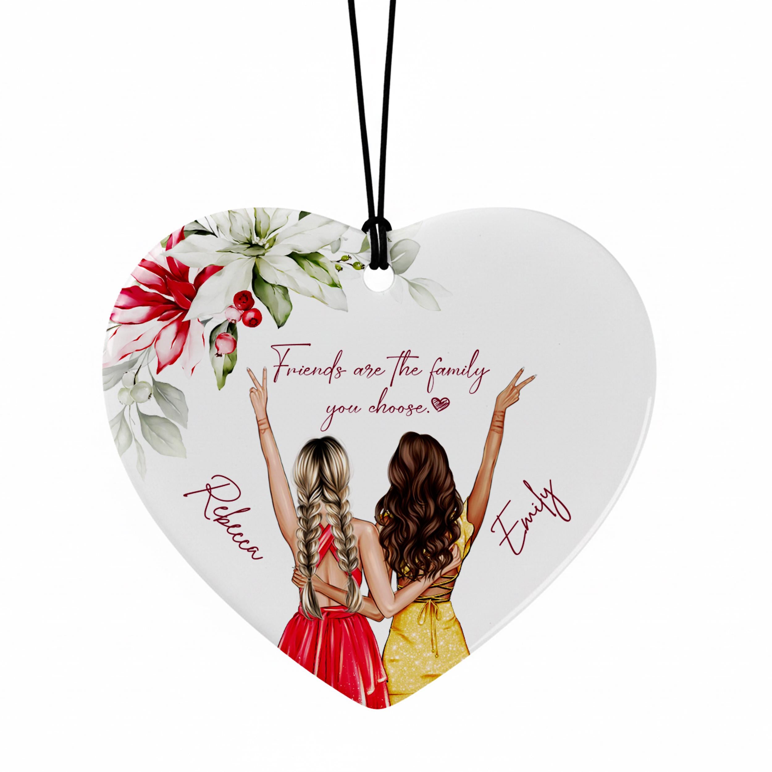 A heart-shaped ornament with two women standing close together, each with their arms raised, and a floral design above them.