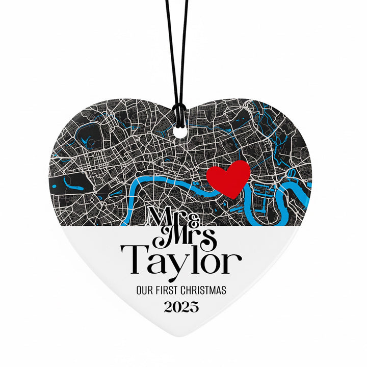 A heart-shaped ornament with a map of London and a red heart symbol, along with the text &quot;Mrs Taylor&quot; and &quot;Our first Christmas&quot; printed on it.