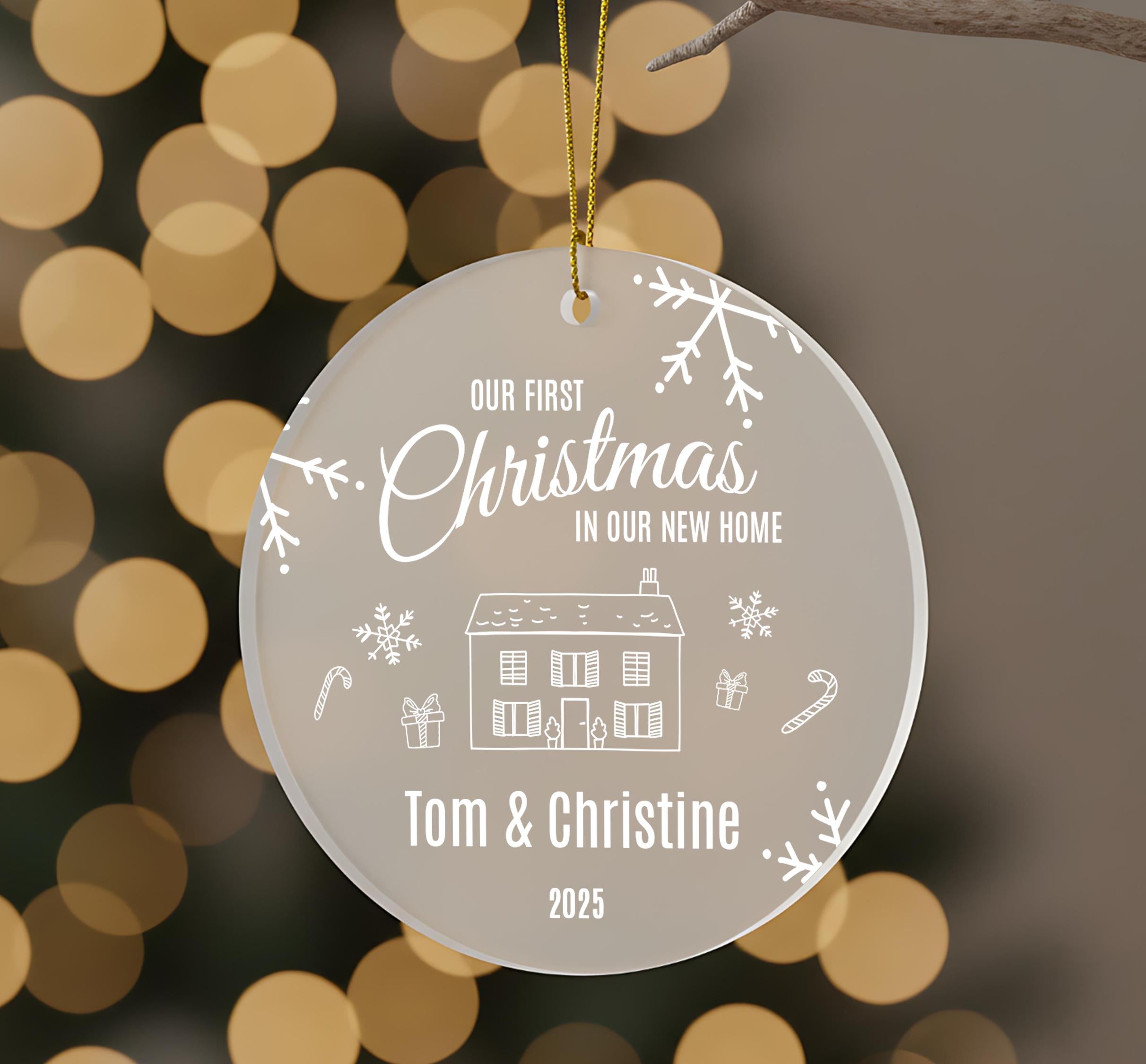 A Christmas ornament with the text "Our first Christmas in our new home" and illustrations of a house, snowflakes, and candy canes.