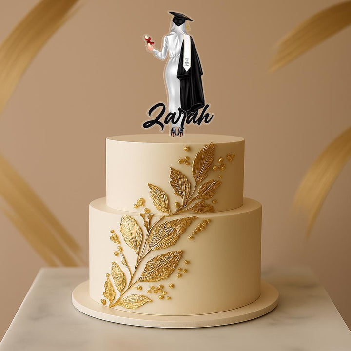 Custom hijabi graduate cake decoration featuring a woman in a white gown and black sash, perfect for Islamic graduation parties.