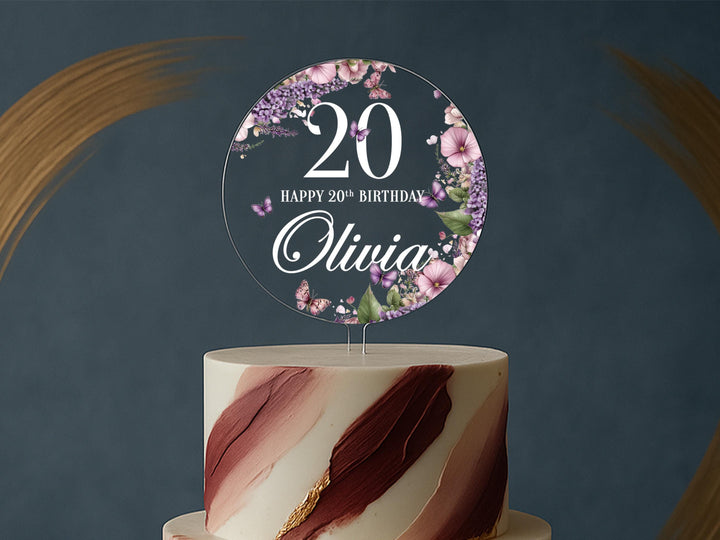 a white and pink cake with a sign on top