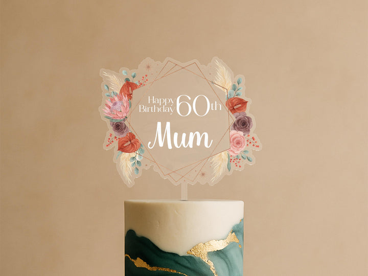 A birthday cake with a decorative topper that says &quot;Happy Birthday 60th Mum&quot;.
