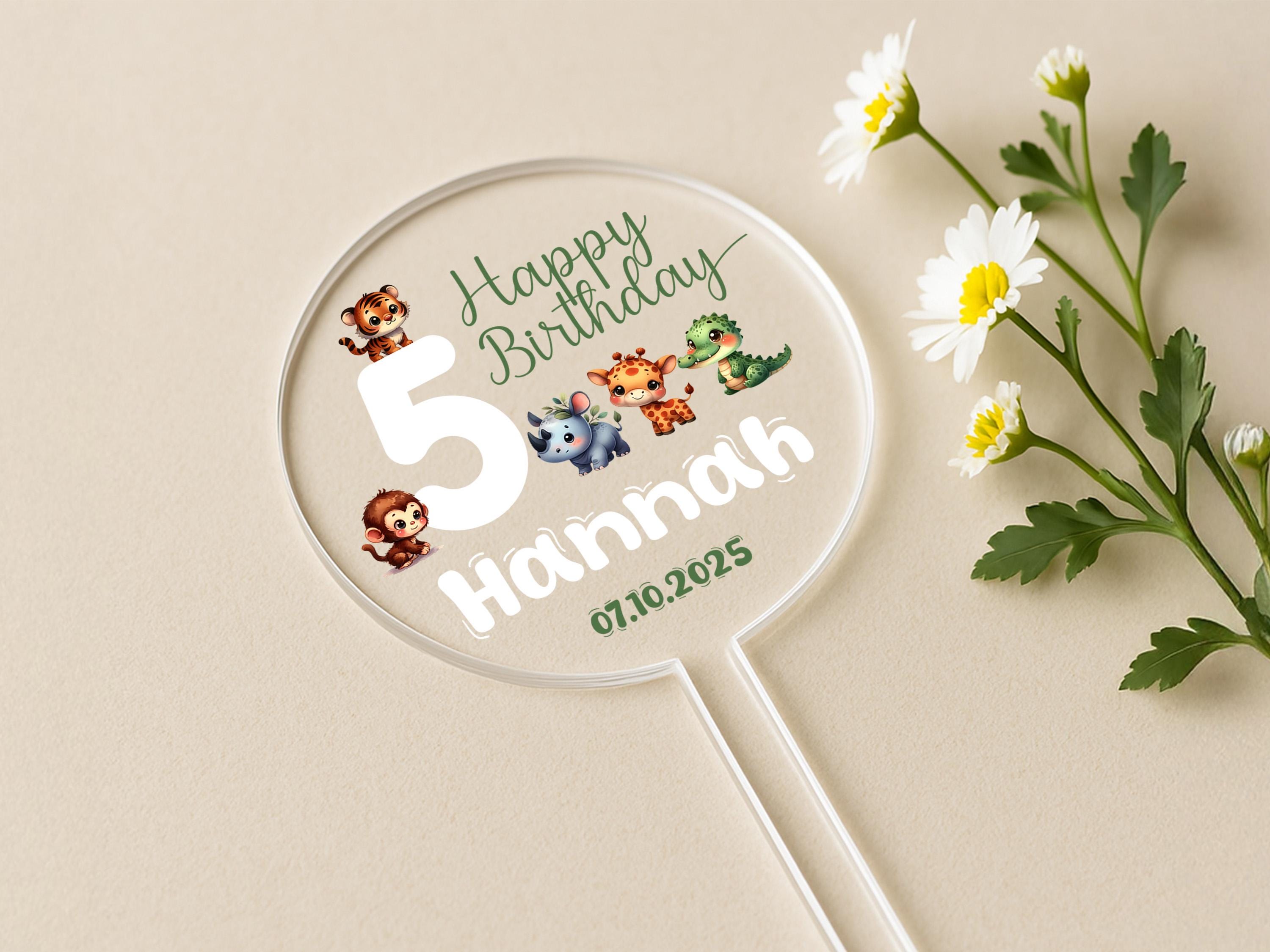 a birthday sticker on a table next to a flower