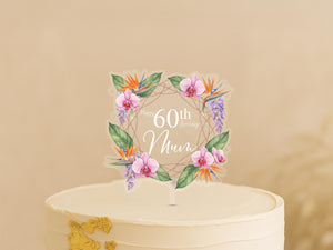 A cake topper with a wreath of flowers and the text "Happy 60th Birthday Mom" on it.