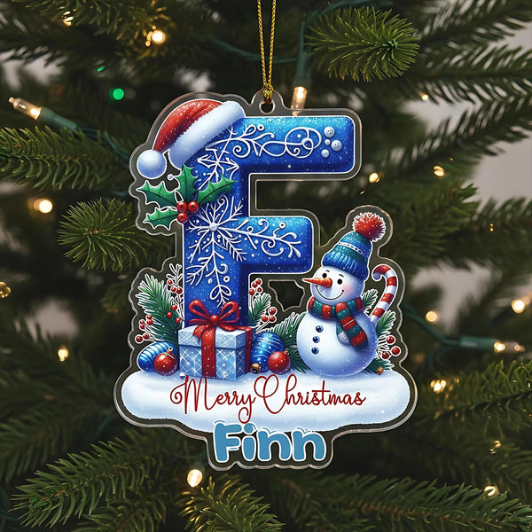 A Christmas ornament with a snowman, presents, and a letter &quot;F&quot; on a tree.